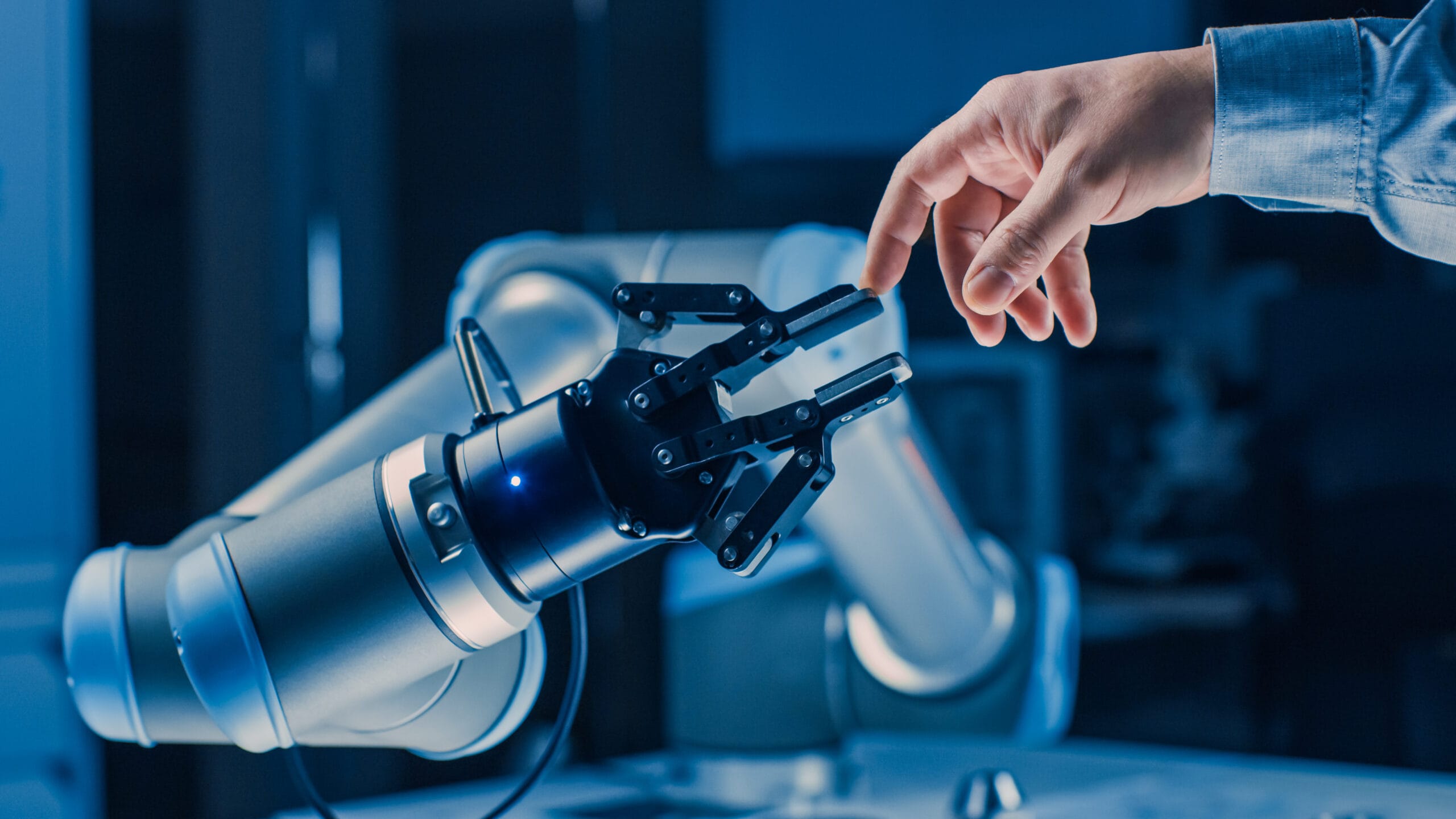 Futuristic Robot Arm Touches Human Hand in Humanity and Artificial Intelligence Unifying Gesture.